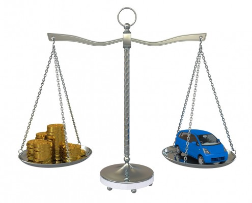 samochód i pieniądze na równoważącej się wadze