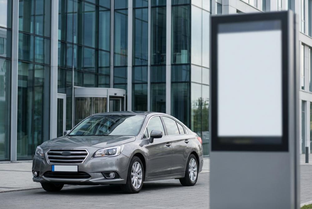 Mężczyzna rejestruje pojazd online na laptopie, w tle formularze i dokumenty samochodowe